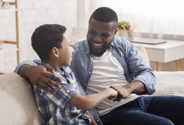 Cheerful Black Boy Bumping Fists With His Dad At Home — Stockfoto