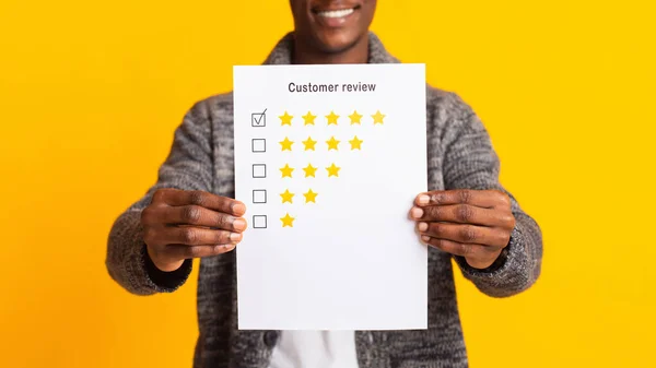 Unrecognizable blurred african man holding customer review — Stockfoto