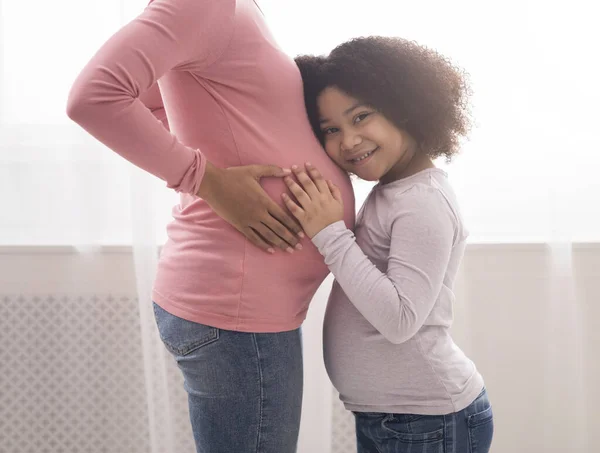 Feliz Expectativa. bonito pouco afro menina abraçando mães grávida barriga — Fotografia de Stock
