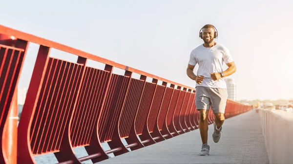 Atlético negro chico disfrutando jogging por puente —  Fotos de Stock