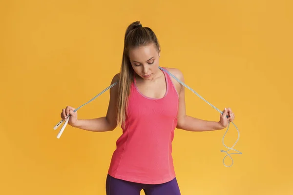 Girl posing with jump rope and looking at her fit body — Stock Fotó