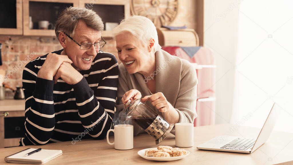 Happy Aged Couple Drinking Coffee, Relaxing Together In Kitchen