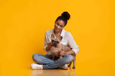 Millennial Afro Dog Sitting On Floor With Her French Bullgod Puppy