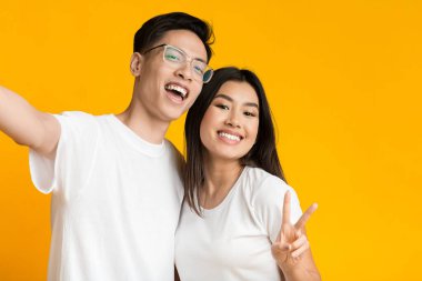 Cute asian couple in love taking selfie