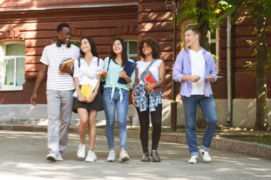 Group of students walking outdoors in university campus together
