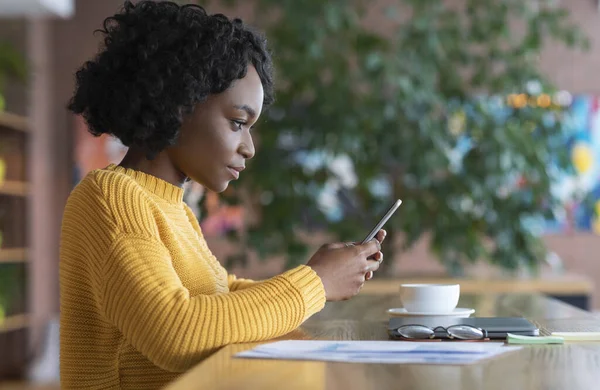 Concentrado menina negra usando smartphone no café — Fotografia de Stock