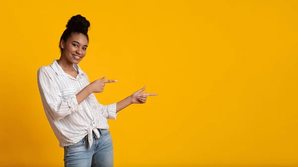 Positive Afro Girl Pointing Aside At Copy Space With Two Fingers — Stockfoto