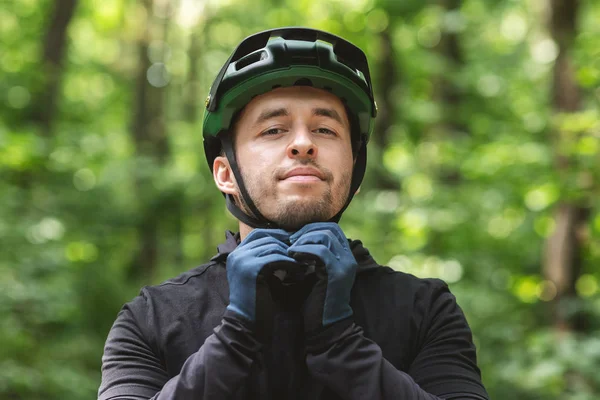 Young sportsman wearing helmet over forest background — Zdjęcie stockowe