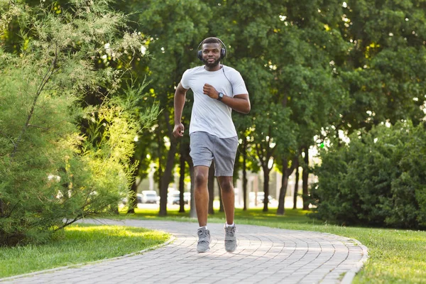 Спортивный чёрный парень занимается спортом в общественном парке — стоковое фото