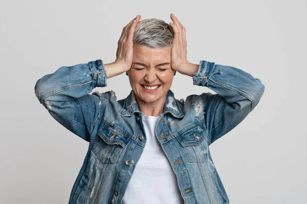 Sick mature woman suffering from acute headache, touching her temples — Stockfoto