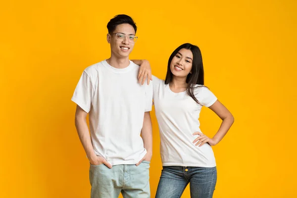 Asian couple in love posing over yellow background — Stok fotoğraf