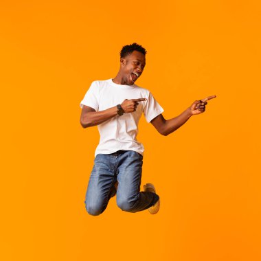 Havalı Afrikalı adam turuncu üzerinde zıplıyor ve hareket ediyor.