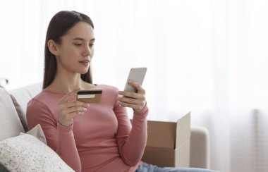 Kredi kartı ile online alışveriş yapan genç bir kız.