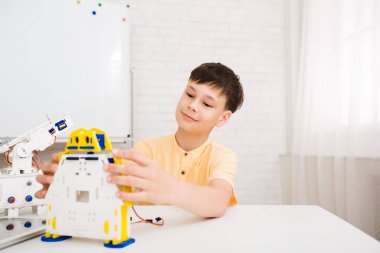 Kök dersi. Akıllı çocuk elektronik oyuncak yapıyor.