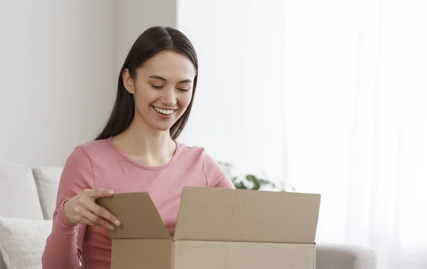 Gelukkige jonge vrouw klant ontvangt post zending pakket — Stockfoto