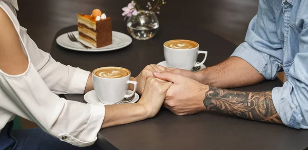 Пара тримає руки, кава в кафе, крупним планом, обрізаний — стокове фото