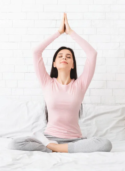 Peaceful woman meditating in bed at home — Stock Photo, Image