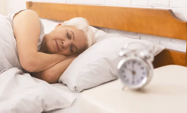 Senior senhora dormindo em sua cama no início da manhã — Fotografia de Stock