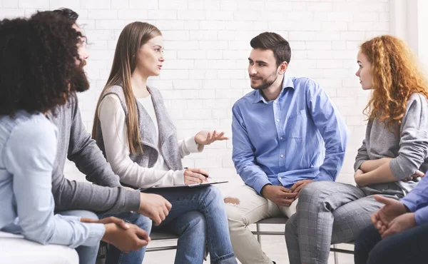 Persone sedute in cerchio e mentore in ascolto durante la sessione di terapia di gruppo — Foto Stock