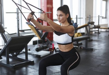 Spor kulübünde kablo TV 'de kaslarını esneten genç bir kadın.