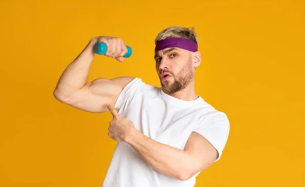 Hombre divertido muestra músculos y levanta pesas — Foto de Stock
