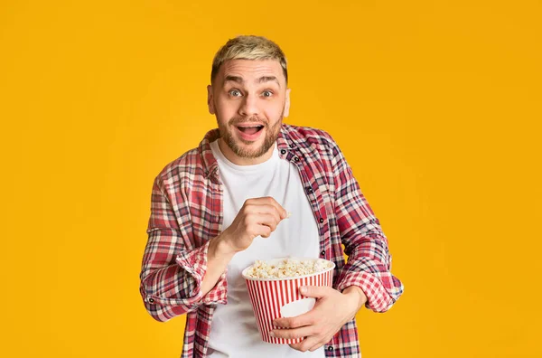 Cara assistindo filme emocionalmente e comendo pipocas — Fotografia de Stock