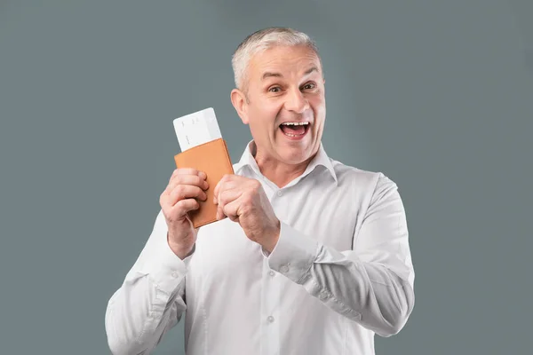 Boldog nyugdíjas férfi kezében jegyek és útlevél — Stock Fotó