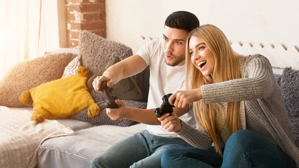 Adorable pareja milenaria jugando videojuegos juntos en casa —  Fotos de Stock