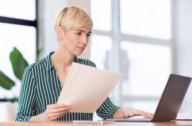 Dizüstü bilgisayarda çalışan girişimci iş raporları ofiste oturuyor.