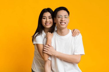 Asyalı aşık bir kız sevgilisine sarılıyor.