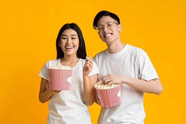 Szczęśliwa azjatycka para ogląda film jedząc popcorn — Zdjęcie stockowe