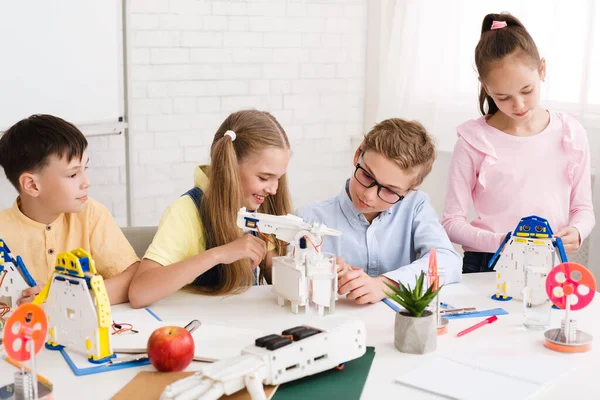 Robotic education. Happy pupils creating robot together — Stock Photo, Image