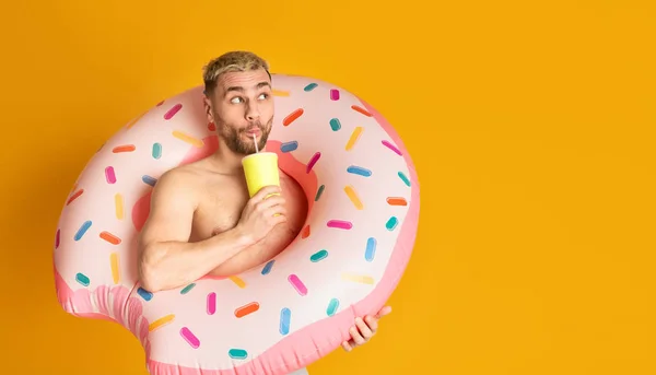 Ridiculous guy in inflatable ring, drinking cocktail — Stock Photo, Image