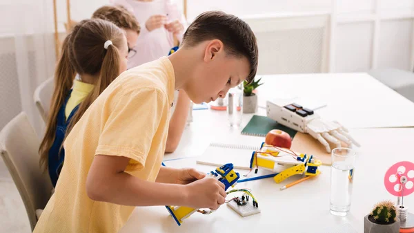 Robotic education. Smart teen boy constructing diy robot — Stock Photo, Image