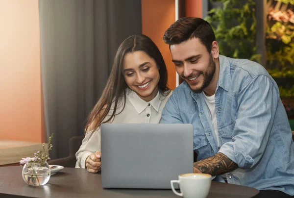 Verliebte sitzen bei romantischem Date mit Laptop in gemütlicher Cafeteria — Stockfoto