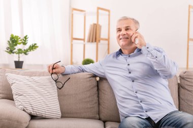 Olgun adam evde cep telefonu üzerinde konuşurken
