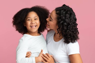 Mutlu annesine sarılan sevimli afro kızın portresi.