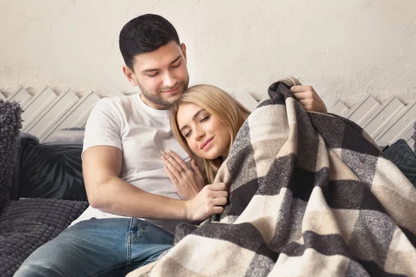 Casal jovem afetuoso com xadrez quente descansando em casa — Fotografia de Stock