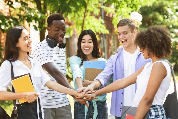 Onderwijs en Eenheid. Groep van internationale studenten stapelen handen samen buiten — Stockfoto