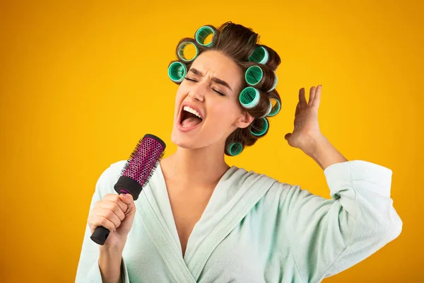 Hausfrau singt mit Haarbürste wie Mikrofon, Studioaufnahme — Stockfoto