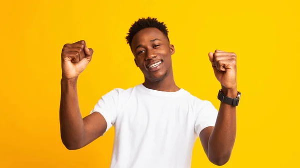 Jovem cara africano alegre se movendo dançando no amarelo — Fotografia de Stock