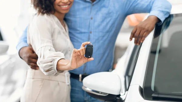 Pareja irreconocible mostrando nueva llave del coche abrazando en concesionario, Panorama —  Fotos de Stock