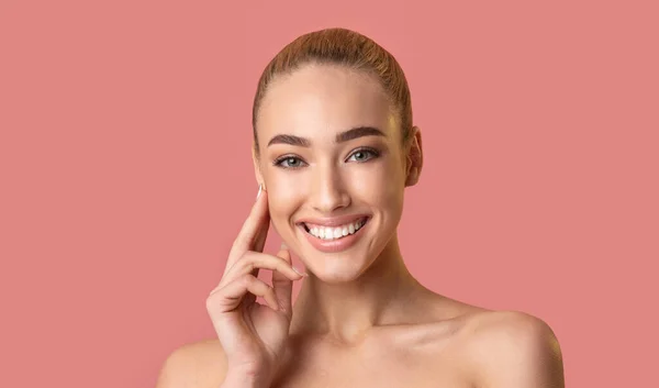 Menina lindo posando toque rosto sorrindo para a câmera, Studio Shot — Fotografia de Stock