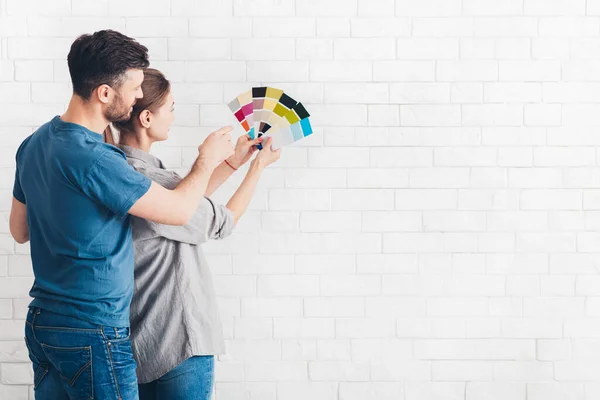Νεαρό ζευγάρι συζητά την ανακαίνιση ενός σπιτιού με χρωματική παλέτα — Φωτογραφία Αρχείου