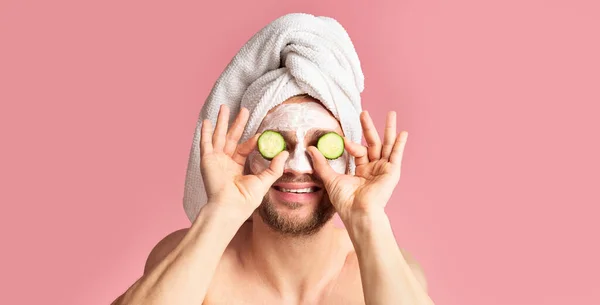 Chico con máscara en la cara aplica pepino a los ojos — Foto de Stock