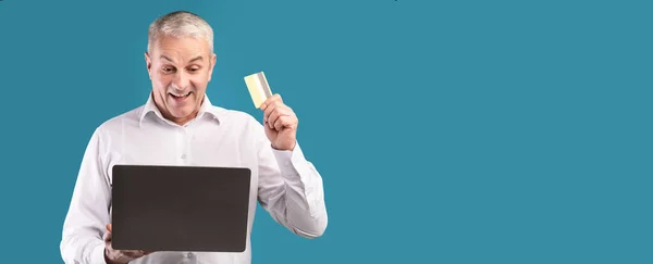 Boldog érett férfi holding kártya és a számítógép — Stock Fotó