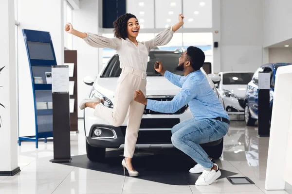 Házastársak ünnepli vásárol auto ugrás örömben a kereskedés Store — Stock Fotó