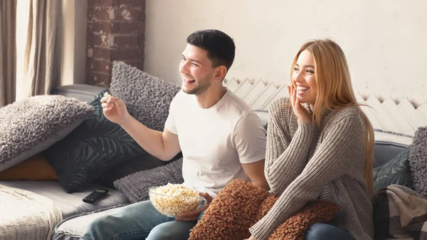 Glückliches junges Paar mit Popcorn schaut lustigen Film zu Hause — Stockfoto
