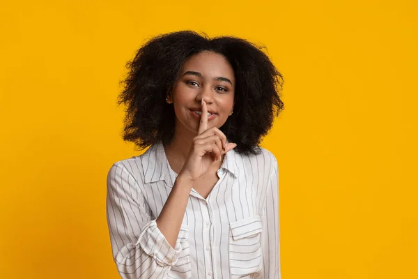 Zwijg. Vrolijk afro meisje tonen shhh teken, houden vinger in de buurt van lippen — Stockfoto