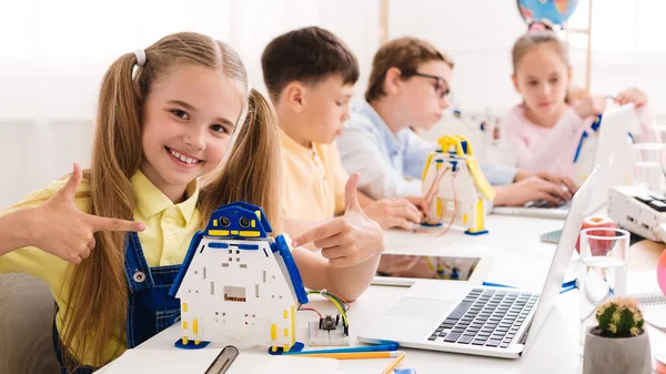 Robotic education. Girl pointing at her robot — Stock Photo, Image